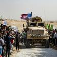 Syrian Kurds protest against a threatened Turkish military invasation next to a US armoured vehicle in Syria's Hasakeh province on October 6, 2019
