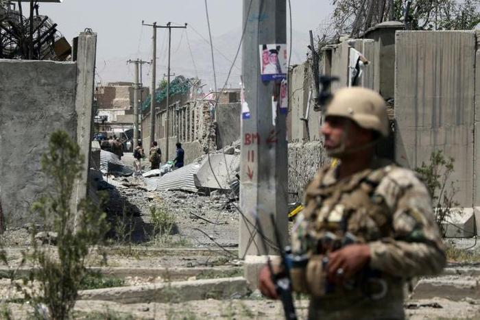 An Afghan security personnel stands guard at the site where a Taliban car bomb detonated at the entrance of a police station in Kabul on August 7