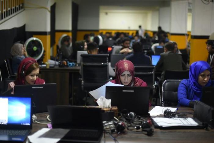 Members of presidential candidate Ashraf Ghani's campaign team answer phone calls at his headquarters in Kabul. His main rival, Abdullah Abdullah, has claimed victory in the vote, even though official results are not due for weeks