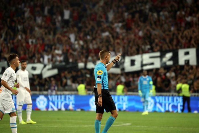 French referee Clement Turpin gestures as he haltes the game between Nice and Marseille after supporters shouted homophobic chants