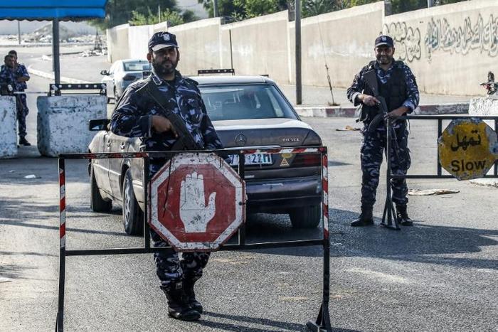 Security forces loyal to Palestinian Islamist movement Hamas man a checkpoint and stop vehicles in Khan Yunis in the southern Gaza Strip on Wednesday after two explosions overnight