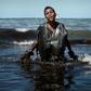 A boy wades ashore covered with oil on Itapuama beach in northeast Brazil on October 21