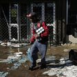 A looter makes off with goods from a store in Germiston, east of Johannesburg, South Africa [Themba Hadebe/The Associated Press]