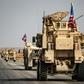 Dozens of US armoured vehicles escorted by helicopters were seen driving through northern Syria