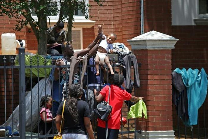 Several hundred asylum-seekers scaled the iron railings of the  United Nations High Commissioner for Refugees office in Pretoria seeking protection