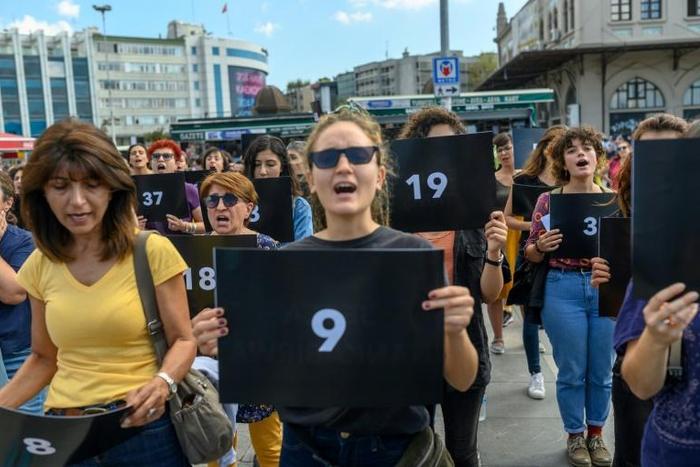 Women held signs with different numbers signifying some of the victims killed this year
