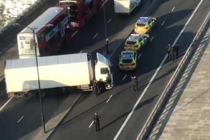Armed police are shown surrounding a white van jackknifed across London Bridge after the incident