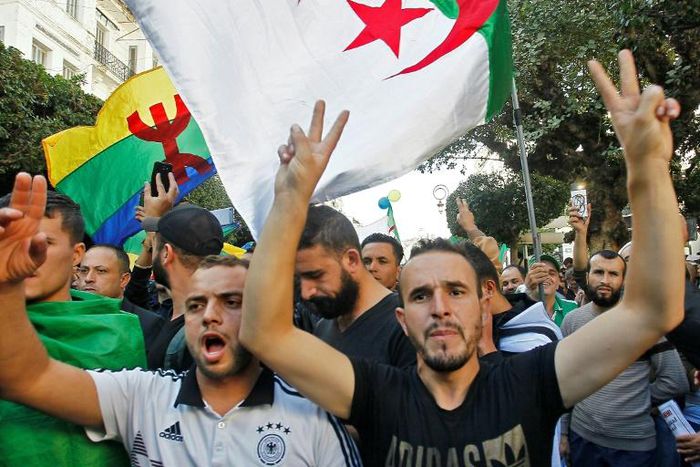 Algerian protesters, with the Berber flag in the background, chant slogans during anti-government demonstrations in the capital Algiers