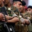Lebanese soldiers wear white roses handed to them by protesters after they ignored pressure from the political establishment to reopen blocked roads, by force if necessary