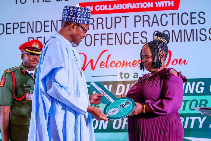 President Muhammadu Buhari honours Mrs Josephine Ugwu, a former cleaner at the Murtala Muhammed International Airport (MMIA), Lagos, who found and returned millions of naira forgotten in the toilet by airport users.[Twitter/@BashirAhmaad]