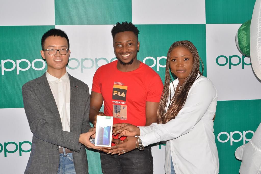 LEFT, Kris Cao, Marketing Director OPPO Nigeria and RIGHT, Nengi Akinola, Marketing Manager, OPPO Nigeria gifiting the OPPO F11 Pro to Sir Dee at the OPPO Head Office, Lagos
