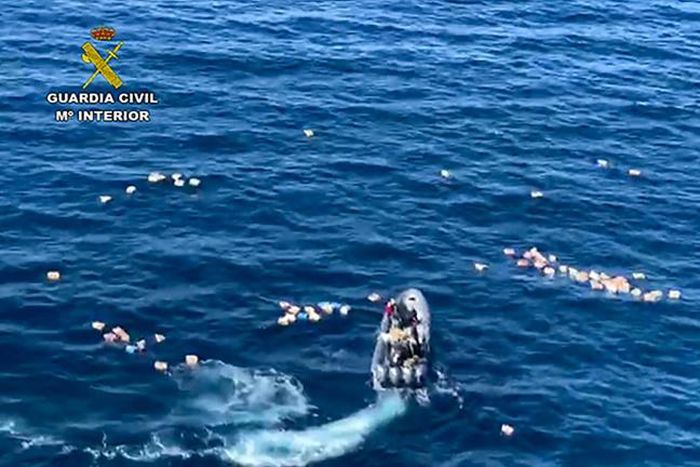 This handout picture released by the Spanish Guardia Civil shows a speedboat surrounded by bundles of drugs in the sea, after a police high-speed chase with drug-smugglers, off the coast of Mijas, Malaga, southern Spain