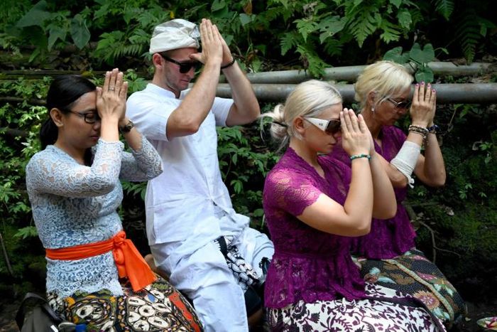 Czech nationals Sabina Dolezalova (2nd R) and her boyfriend Zdenek Slouka (2nd L) took part in a purification ritual in Bali after a disrespectful online video they posted went viral
