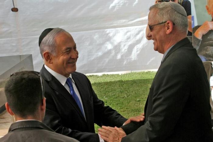 Israeli Prime Minister Benjamin Netanyahu (L) greets rival Benny Gantz, leader of Blue and White party, at a memorial ceremony for late Israeli president Shimon Peres on Thursday