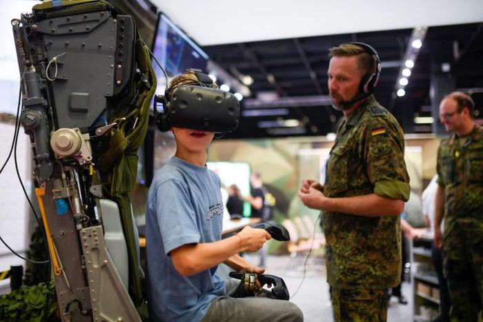 Dozens of young gamers visited Germany's army stall to test out a helicopter simulator