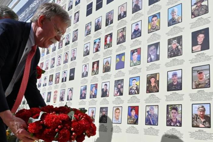 White House national security adviser John Bolton lays flowers at a memorial for those killed in Ukraine's war against Russia-backed separatists