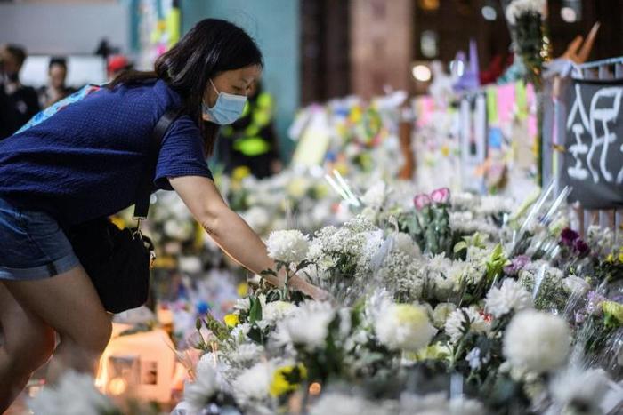 Mourners pay their respects at the site where a student fell to his death during a recent protest