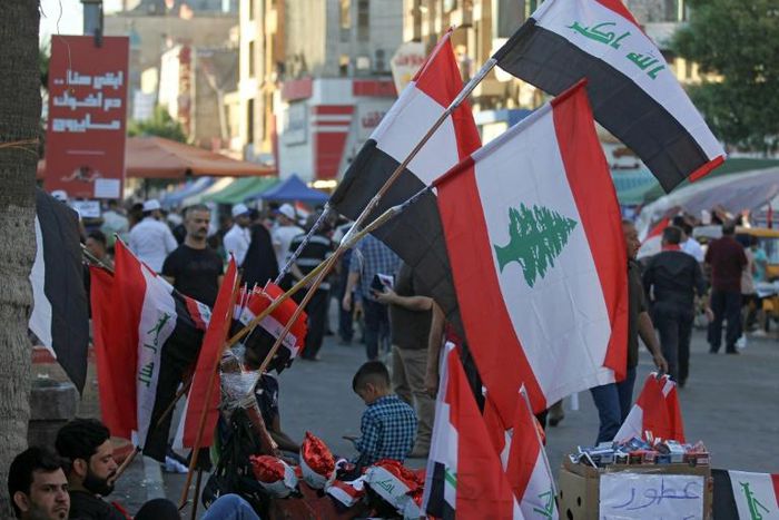 A Baghdad street vendor sells flags of Iraq and Lebanon, both gripped by anti-government protests