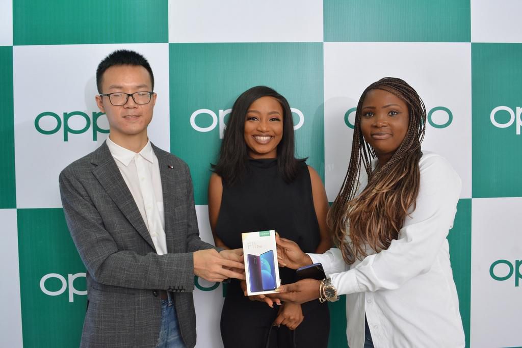 LEFT, Kris Cao, Marketing Director OPPO Nigeria and RIGHT, Nengi Akinola, Marketing Manager, OPPO Nigeria gifiting the OPPO F11 Pro to Esther at the OPPO Head Office, Lagos