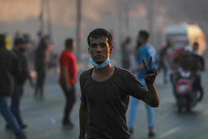An Iraqi demonstrator flashes the victory sign during a demonstration in Baghdad Saturday