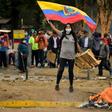A demonstrator waves an Ecuadoran flag during clashes with riot police amid protests over a fuel price hike ordered by the government to secure an IMF loan on October 12, 2019