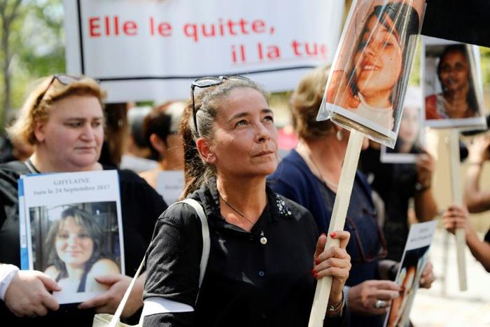 A woman holds the picture of a victim as she takes part in a protest march denouncing violence against women in Paris