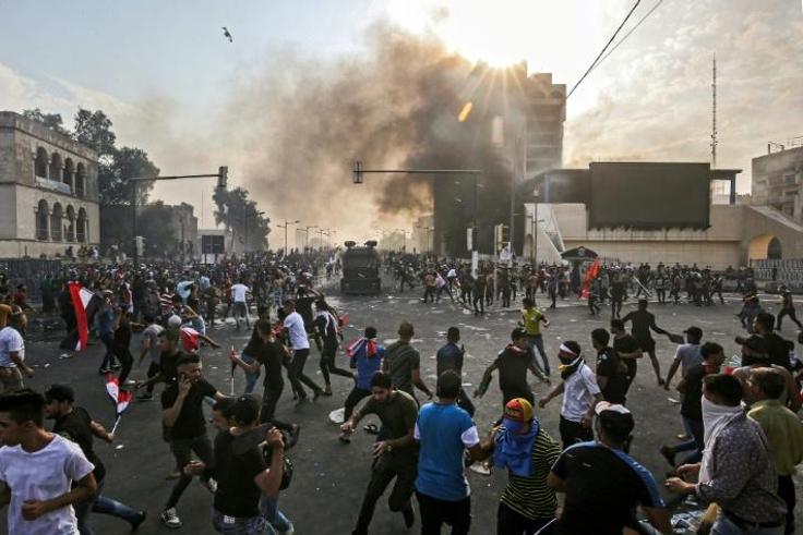 Protesters clash with an Iraqi riot police during a demonstration against state corruption and poor services in Baghdad