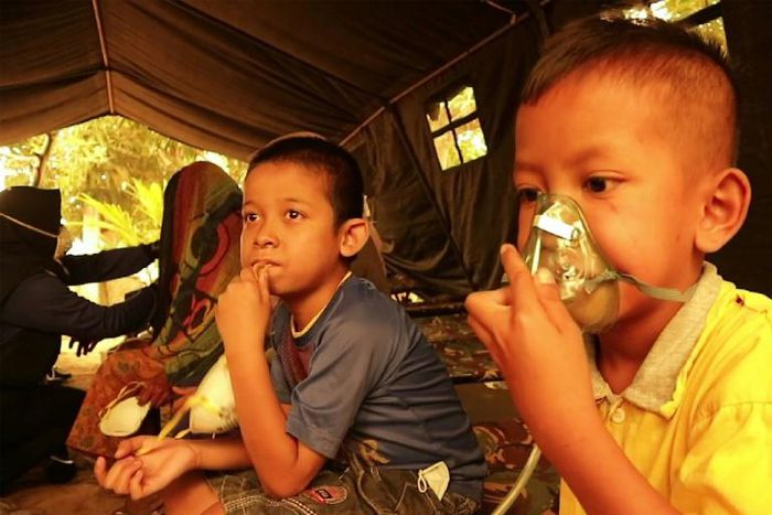 Indonesian children get a dose of oxygen from a Red Cross volunteer. UNICEF says the forest fires are puttling nearly 10 million children at risk from the toxic air