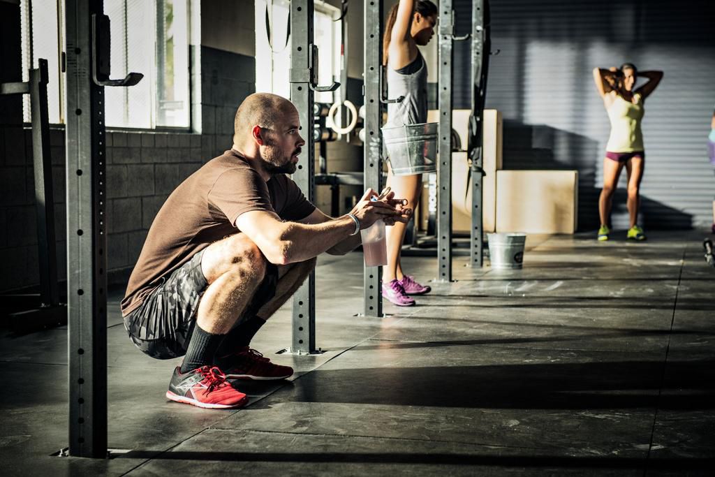Men and women warming up for training in gymnasium