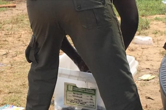 Police officer seen in Bayelsa washing his uniform with a ballot box.  (TheCable)