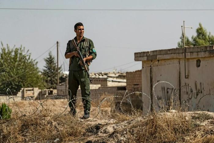 Kurdish security forces stand guard during a demonstration by Syrian Kurds against Turkish threats of a military operation in northern Syria