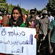 A woman holds up a sign reading in Arabic: "The people demand retribution for the martyrs", during a demonstration in the centre of Sudan's capital