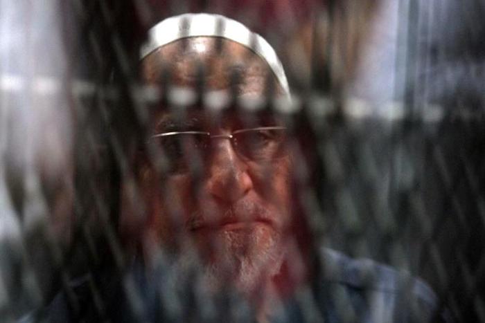 Egyptian Muslim Brotherhood Supreme Guide Mohamed Badie is seen behind bars during a hearing for him and other Brotherhood members on charges of espionage, as the country's crackdown on the Islamist group continues