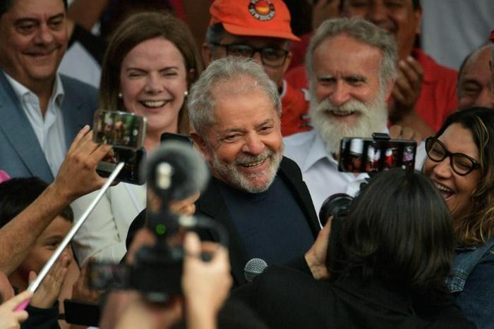 Former Brazilian president Luiz Inacio Lula da Silva smiles next to his girlfriend after leaving the federal police headquarters in Curitiba, where he was serving a sentence for corruption and money laundering