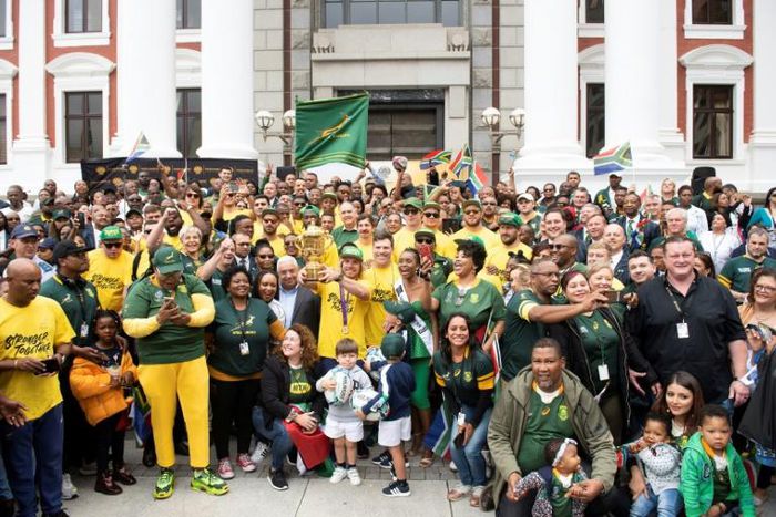 Rainbow nation: Springbok scrum half Faf de Klerk holds the William Webb Ellis Trophy alongside his teammates outside the South African parliament in Cape Town