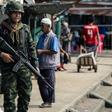 A Thai soldier patrols the Tak Bai riverside market on Friday's anniversary