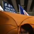 A flag that reads "Hong Kong Independence" is seen alongside the territory's British colonial-era flag and the pro-independence 'Estelada' Catalan flag during a march in Hong Kong on China's national day