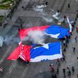 Demonstrators in Santiago carried a torn Chilean flag on October 25, 2019, as sometimes violent protests over both political and economic demands showed little sign of abating