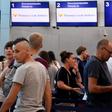 Passengers stand in line at the closed Thomas Cook check-in desk at the airport in Cancun, Mexico, on September 23, 2019