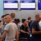 Passengers stand in line at the closed Thomas Cook check-in desk at the airport in Cancun, Mexico, on September 23, 2019