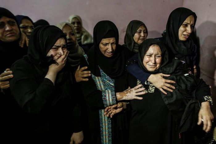 Relatives mourn for one of three Palestinians killed by Israeli fire along the border with the Gaza Strip