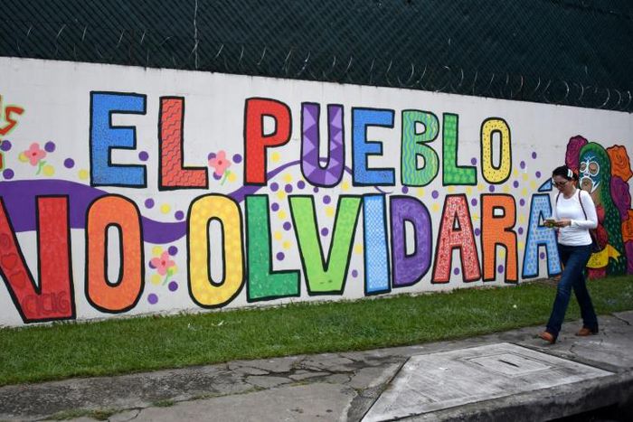 A woman walks by a mural painted outside the headquarters of the UN International Commission Against Impunity (CICIG)