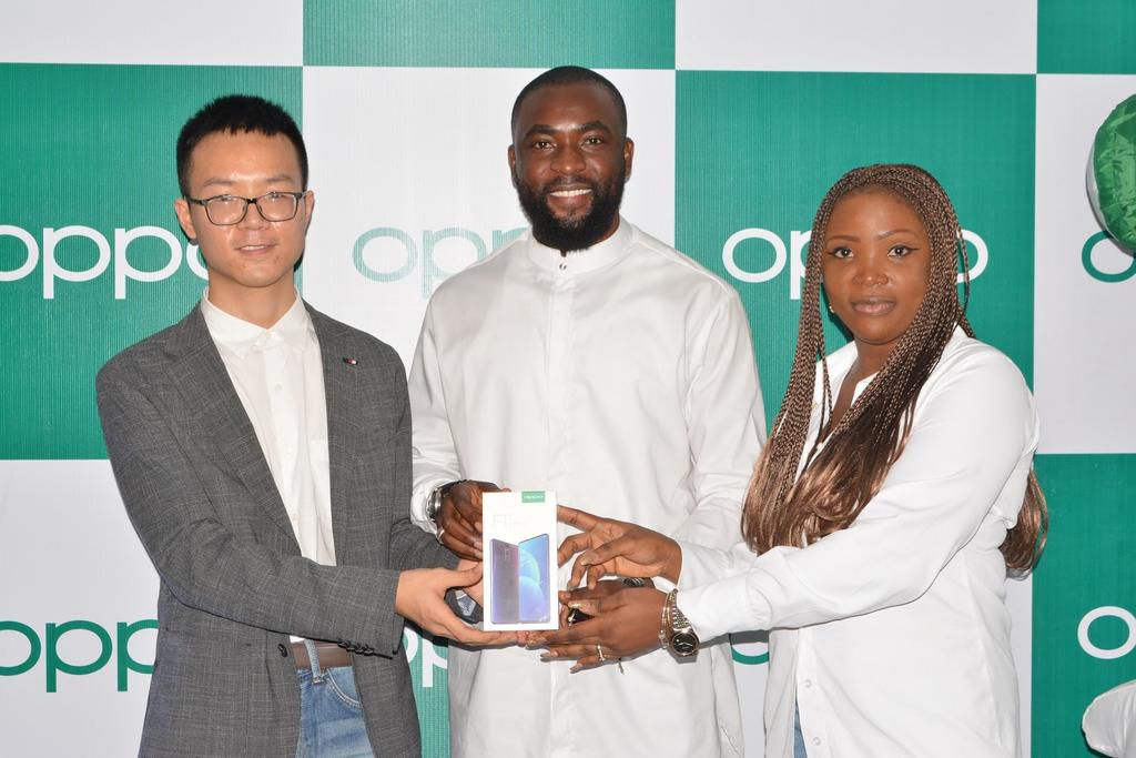 LEFT, Kris Cao, Marketing Director OPPO Nigeria and RIGHT, Nengi Akinola, Marketing Manager, OPPO Nigeria gifiting the OPPO F11 Pro to Gedoni at the OPPO Head Office, Lagos