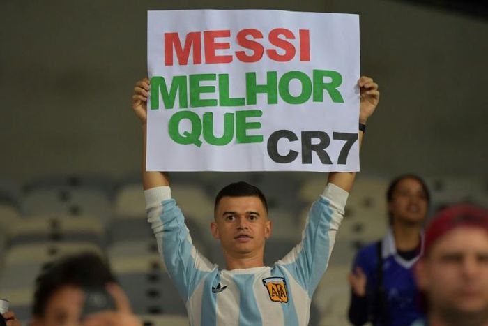 A fan of Argentina displays a placard reading "Messi better than CR7" at the start of the Copa America match against Paraguay in June