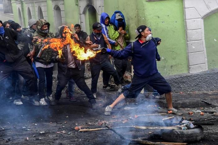 Demonstrators clash with riot police in Quito. The protestors are demanding the president reinstate fuel subsidies which were cut last week