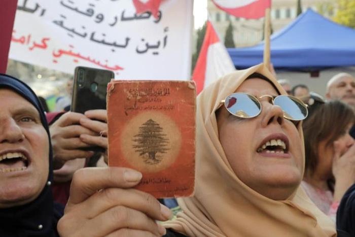 A Lebanese demonstrator holds up an old identity card during a march organised by the "My Nationality, My Dignity" campaign in Beirut