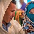 A young Amazigh couple smile at each other as they wait for their turn at a group wedding in Morocco's Atlas mountains