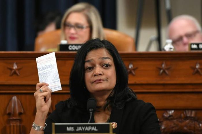 Democratic lawmaker Pramila Jayapal holds up a copy of the Constitution as she votes to impeach President Donald Trump