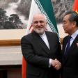 China's Foreign Minister Wang Yi shakes hands with his Iranian counterpart Mohammad Javad Zarif during their meeting in Beijing in December 2019