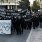 Black block protesters march behind a banner reading 'from a spontaneous uprising to the constant struggle' in Athens